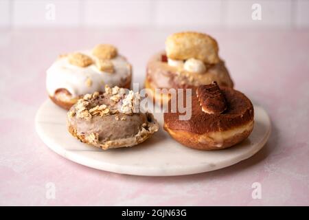 Mehrere Arten von Donuts auf einer Marmorplatte, Essen Stockfoto