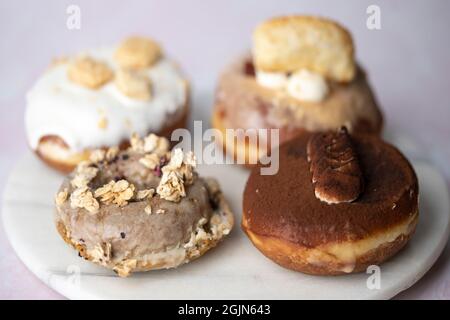 Mehrere Arten von Donuts auf einer Marmorplatte, Essen Stockfoto