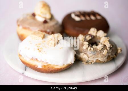 Mehrere Arten von Donuts auf einer Marmorplatte, Essen Stockfoto