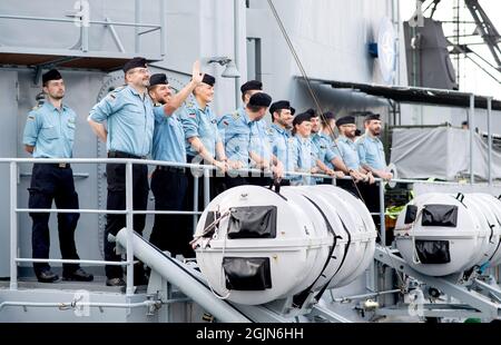 Wilhelmshaven, Deutschland. September 2021. Besatzungsmitglieder winken von der Fregatte 'Lübeck' aus, als sie den Marinestützpunkt erreicht. Das Marineschiff war Anfang Mai in den Einsatz gekommen, um der „Standing NATO Maritime Group 2“ in der Ägäis beizutreten, die Maßnahmen gegen den Schmuggel im Meeresgebiet unterstützt. Quelle: Hauke-Christian Dittrich/dpa/Alamy Live News Stockfoto