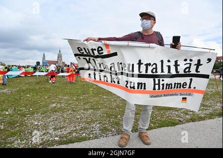 13. März 2020, Bayern, München: Ein Demonstrator hält ein Plakat mit der Aufschrift "Deine Klimaneutralität stinkt nach dem Himmel. Staatlich legitimierter Bullshit“. Unter dem Motto '#getout' findet eine Demonstration und eine Fahrradrallye gegen die Internationale Automobil-Ausstellung (IAA) statt. Die Polizei erwartet für die Fahrradrallye bis zu 35,000 Teilnehmer und für die Demonstration bis zu 10,000 Teilnehmer. Foto: Felix Kästle/dpa Stockfoto