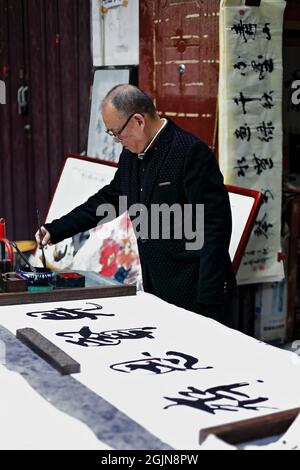 Chinesischer Kalligraph praktiziert seine kalligraphischen Fähigkeiten-Shuyuanmen Alte Kultur-Kalligraphie Straße. XI'an-China-1569 Stockfoto