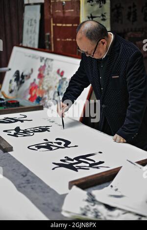 Chinesischer Kalligraph praktiziert seine kalligraphischen Fähigkeiten-Shuyuanmen Alte Kultur-Kalligraphie Straße. XI'an-China-1570 Stockfoto
