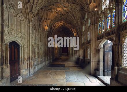 Kreuzgang mit Sonnenstrahlen, die durch die Gloucester Cathedral in Gloucester, Gloucestershire, durchdringen Stockfoto