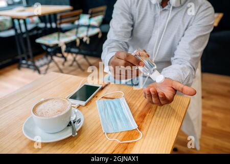 Nicht erkennbarer Mann, der seine Hände mit hydroalkoholischem Gel desinfiziert Stockfoto