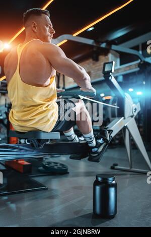 Protein-Molkenpulver in schwarzen Behälter und Bodybuilder männlichen Training im Fitnessstudio Stockfoto