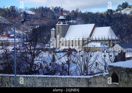 Blick über die Altstadt von Brasov in Rumänien im Winter, mit der gotischen Schwarzen Kirche (Biserica Neagra) im Zentrum. Stockfoto