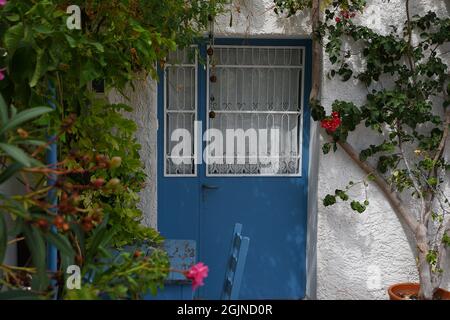 Traditionelle ländliche Haus hellblau geschmiedeten Eisen Eingangstür mit handgefertigten Gitter an einer weiß getünchten Wand in Galaxidi, Phocis Griechenland. Stockfoto