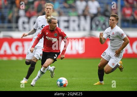 Hannover, Deutschland. September 2021. Fußball: 2. Bundesliga, Hannover 96 - FC St. Pauli, Matchday 6 in der HDI Arena. Hannovers Niklas Hult (M) spielt gegen St. Paulis Christopher Avevor (l) und Finn Ole Becker. Quelle: Swen Pförtner/dpa - WICHTIGER HINWEIS: Gemäß den Bestimmungen der DFL Deutsche Fußball Liga und/oder des DFB Deutscher Fußball-Bund ist es untersagt, im Stadion und/oder vom Spiel aufgenommene Fotos in Form von Sequenzbildern und/oder videoähnlichen Fotoserien zu verwenden oder zu verwenden./dpa/Alamy Live News Stockfoto