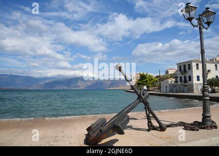 Malerische Küstenlandschaft mit einem alten handgefertigten gusseisernen Anker am malerischen Hafen von Galaxidi in Phocis, Griechenland. Stockfoto