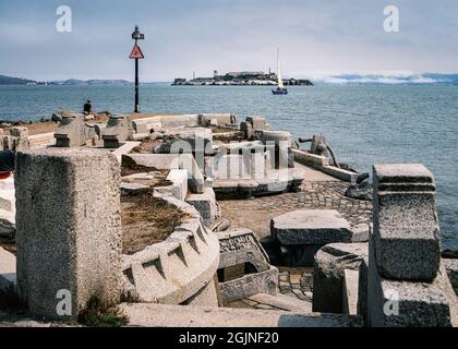 Ein Segelboot fährt zwischen der Wave Organ und Alcatraz in San Francisco Stockfoto