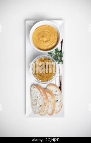 Draufsicht auf Gänseleber-Pastete mit Apfelchutneys und Brot auf weißem Hintergrund Stockfoto