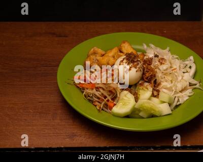 Ein Teller mit „Gado-Gado“, einem traditionellen indonesischen Salat, der Sprossen, Gurken, gebratenen Tofu, Ei, Kohl, Karotten usw. Stockfoto