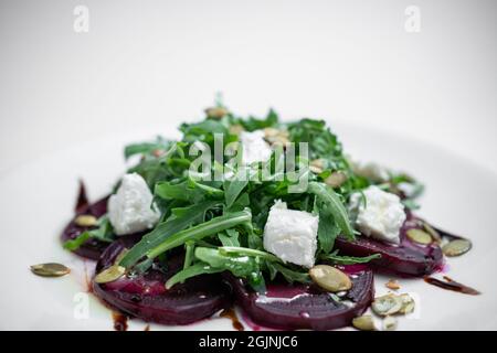 Nahaufnahme des Salats mit Rüben, Rucola und Feta-Käse auf weißem Hintergrund Stockfoto