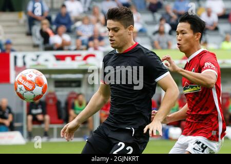 Freiburg Im Breisgau, Deutschland. September 2021. Fußball: Bundesliga, SC Freiburg - 1. FC Köln, Matchday 4, Dreisamstadion: Der Kölner Jorge Méré Pérez im Duell mit dem Freiburger Woo-Yeong Jeong Credit: Philipp von Ditfurth/dpa - WICHTIGER HINWEIS: Gemäß den Bestimmungen der DFL Deutsche Fußball Liga und/oder des DFB Deutscher Fußball-Bund ist es untersagt, im Stadion und/oder vom Spiel aufgenommene Fotos in Form von Sequenzbildern und/oder videoähnlichen Fotoserien zu verwenden oder zu verwenden./dpa/Alamy Live News Stockfoto