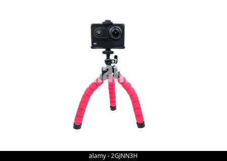Die Action-Kamera steht auf einem Mini-Stativ, isoliert auf weißem Hintergrund, Stockfoto