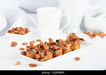 Kleine Kuchen mit Mandeln, Rosinen und Honig auf einem weißen Tisch. Stockfoto