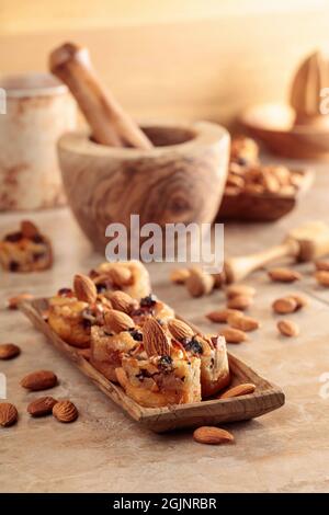 Kleine Kuchen mit Mandeln, Rosinen und Honig auf einem braunen Tisch. Stockfoto