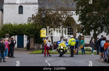 Gifford, East Lothian, Schottland, Großbritannien, 11. September 2021. AJ Bell Tour of Britain: Die Etappe 7 der Radrenntour führt durch das Dorfzentrum von East Lothian, während eine kleine Menge wartet. Im Bild: Ein Polizeichef hält für Fotos mit Menschen in der Menge an Stockfoto