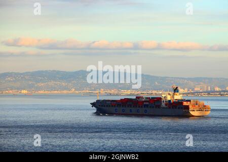 COSCO Containerschiff in der Bucht von San Francisco bei Sonnenuntergang in der Stadt San Francisco, Kalifornien CA, USA. Stockfoto