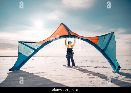 Sportliche Mädchen steht und halten Snowkite in den Händen. Winter Kitesurfing Konzept Stockfoto