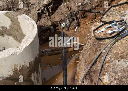 Betonring. Ein Brunnen aus Beton im gegrabenen Boden. Bauarbeiten. Stockfoto