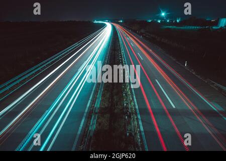Highway bei Nacht mit leichten Wegen auf der Straße Stockfoto