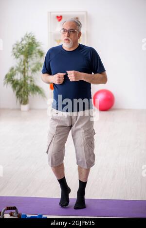 Alter Mann, der zu Hause Sportübungen macht Stockfoto