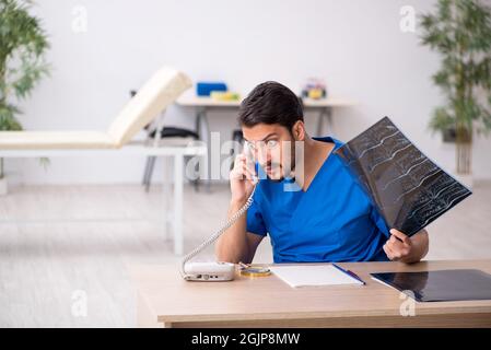 Junger Radiologe, der in der Klinik sitzt Stockfoto