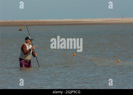 BUENOS AIRES, ARGENTINIEN - 10. Nov 2008: Ein Blick auf Fischer im Meer, die ihre Netze in Punta Rasa, Buenos Aires, Argentinien kontrollieren Stockfoto