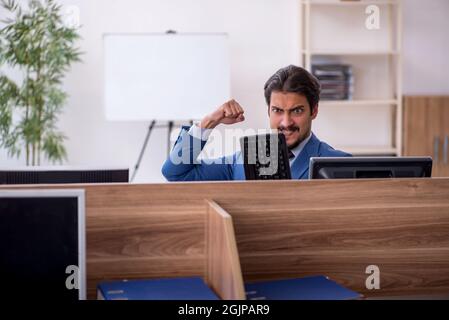 Junger Geschäftsmann Mitarbeiter am Arbeitsplatz sitzen Stockfoto