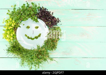 Mehrere Arten von Mikrogrüns auf einem hölzernen Hintergrund. Microgreens verschiedener Sorten auf einem hölzernen Hintergrund. Stockfoto