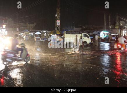 Beawar, Rajasthan, Indien, 11. September 2021: Pendler waten in Beawar bei starkem Regen durch eine wasserbefahrte Straße. Kredit: Sumit-Samarwat/Alamy Live Nachrichten Stockfoto