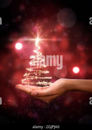 Roter Weihnachtsbaum in der Hand. Weihnachtsbaum, schöne Lichter, Sterne und Schneeflocken Stockfoto