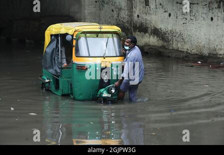 Neu-Delhi, Indien. September 2021. Ein Mann zieht seine Auto-Rikscha durch eine wasserdurchsetzte Zakhira-Unterführung nach starken Regenfällen in Neu-Delhi. Die Verkehrspolizei von Delhi schloss mehrere Unterführungen und Straßen, um den Verkehr aufgrund von starken Regenfällen und Wassereinschlägen in vielen Gebieten zu vermeiden, darunter auch dem internationalen Flughafen Indira Gandhi. Das Indian Meteorological Department (IMD) kündigte Gewitter mit sehr starken Regenfällen in der Hauptstadt an. (Foto von Naveen Sharma/SOPA Images/Sipa USA) Quelle: SIPA USA/Alamy Live News Stockfoto