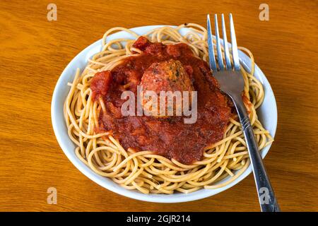 Vollkornspaghetti mit Pasta-Sauce und Fleischbällchen auf pflanzlicher Basis in einer Schüssel toppen Stockfoto