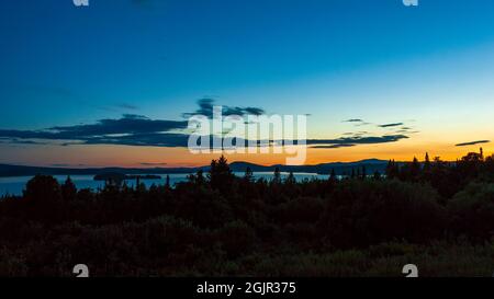 Ein ruhiger Sommeruntergang über dem Rangeley Lake, vom Whip Willow Farm Scenic Overlook auf dem Rangeley Lakes National Scenic Byway aus gesehen. Rangeley, ICH Stockfoto