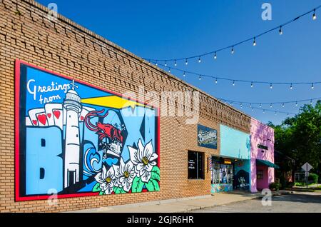 Auf der Seite eines Gebäudes an der Howard Avenue und G.E. ist ein Postkartengemälde mit dem Titel „Grüße von Biloxi“ gemalt OHR Street in Biloxi, Mississippi. Stockfoto