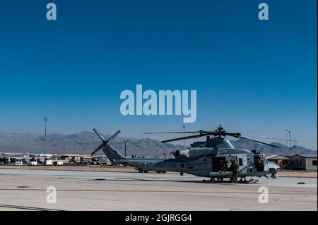 US-Marineinfanteristen vom 4. Marine Aircraft Wing, Marine Light Helicopter Attack Squadron 775, bereiten einen Bell UH-1Y Venom Huey Super Huey Hubschrauber für den Start vor, um eine Live-Feuertrainingsmission mit Airmen vom 66. Waffengeschwader auf der Nellis Air Force Base, Nevada, durchzuführen, 27. August 2021. Auf der Nellis AFB wird das ganze Jahr über ein gemeinsames taktisches Luft- und Landtraining durchgeführt, das es allen Zweigstellen des Verteidigungsministeriums ermöglicht, ihre Taktik und Verfahren zu schärfen, um die Herausforderungen des Landes abzuschrecken und zu bekämpfen. (USA Air Force Foto von Tech. Sgt. Alexandre Montes) Stockfoto