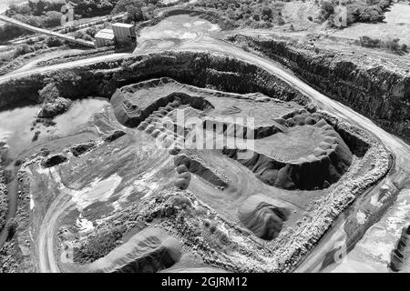 Industriegebiet der Basalt-Tagebaumine und -Steinbrüche an der australischen Südküste in NSW - von oben nach unten als Kontrast schwarz-weiß. Stockfoto