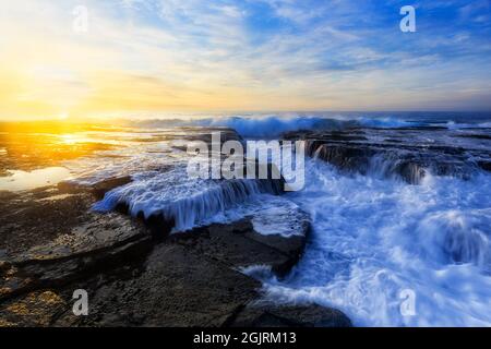 Sydney Nordstrände der Pazifikküste bei schönem Sonnenaufgang um Sandsteinfelsen am Strand Narrabeen. Stockfoto