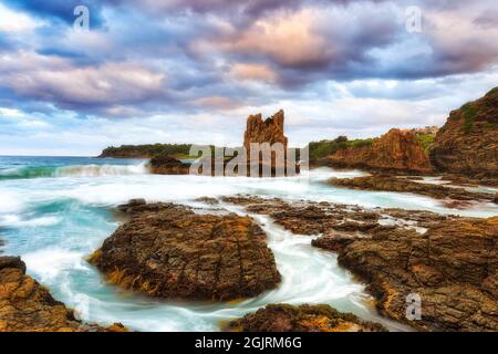 Malerische erodierte Felsformationen, die bei Sonnenuntergang in Kiama an der Pazifikküste Australiens als Cathedral Rock bezeichnet werden. Stockfoto