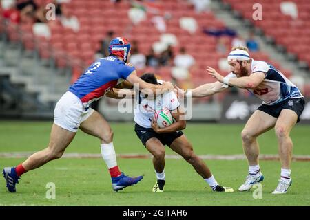 SINGAPUR-13. APRIL: Die 7er-Mannschaft aus Hongkong (weiß) spielt am 1. Tag des HSBC World Rugby Singapore Sevens am 13. April 2019 im Nationalstadion in Singapur gegen die 7er-Mannschaft aus Frankreich (blau) Stockfoto