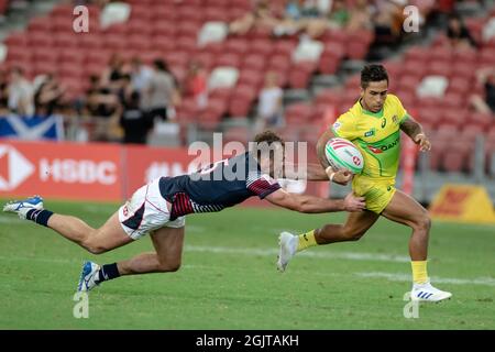 SINGAPUR-APRIL 13:Australien 7s Team (gelb) spielt am 1. Tag des HSBC World Rugby Singapore Sevens am 13. April 2019 im Nationalstadion in Singapur gegen das 7s Team aus Hongkong (blau/rot) Stockfoto