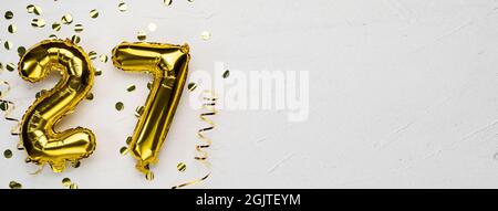 goldene Folienballon Zahl siebenundzwanzig. Geburtstags- oder Jubiläumskarte mit der Aufschrift 27. Grauer Betonhintergrund. Jubiläumsfeier. Bann Stockfoto