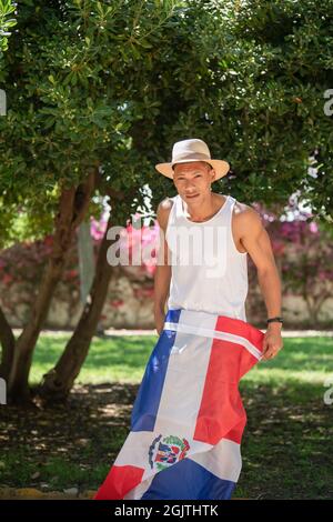 Latino-Mann mit der Flagge der Dominikanischen Republik beim Blick auf die Kamera: Selektiver Fokus. Diversity-Konzept. Stockfoto