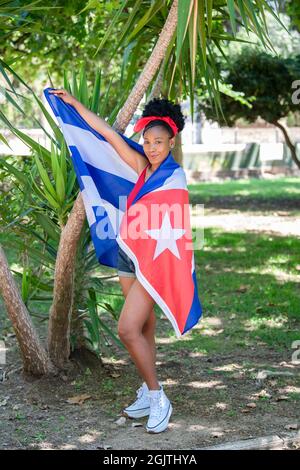 Latina Frau in kubanische Flagge gehüllt lächelnd auf die Kamera Stockfoto