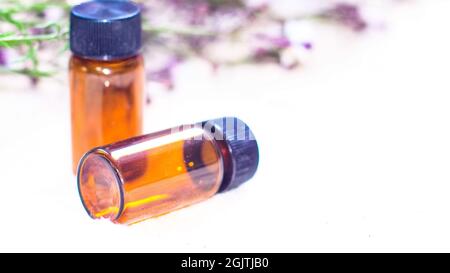 Flasche ätherisches Öl. Kräutermedizin oder Aromatherapie dropper Flasche auf weißem Hintergrund. Frischem Rosmarin Blüten und ätherischen Ölen auf der Stockfoto