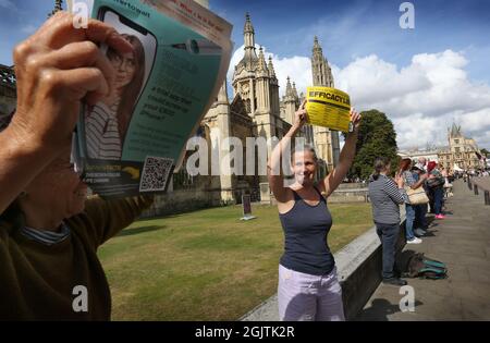 Cambridge, Großbritannien. September 2021. Demonstranten halten Plakate hoch, während sich Truthers vor dem Kings College in Cambridge treffen, um Lärm zu machen, halten die Hände in einer Schlange und zeigen den Menschen, dass sie „wach“ sind, während sie gegen Impfpass und Impfung für Kinder demonstrieren. Die Veranstaltung findet in Städten und Städten in ganz Großbritannien statt. Für den Zugang zu überfüllten Orten wie Nachtclubs und Sportveranstaltungen werden Ende September 2021 Impfpass benötigt. (Foto von Martin Pope/SOPA Images/Sipa USA) Quelle: SIPA USA/Alamy Live News Stockfoto