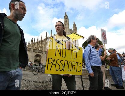 Cambridge, Großbritannien. September 2021. Demonstranten, die einige Plakate halten, bilden sich in eine Reihe, als sich die Truther vor dem Kings College, Cambridge, treffen, um Lärm zu machen, die Hände in eine Reihe zu halten und den Menschen zu zeigen, dass sie „wach“ sind, während sie gegen Impfpass und Impfung für Kinder demonstrieren. Die Veranstaltung findet in Städten und Städten in ganz Großbritannien statt. Für den Zugang zu überfüllten Orten wie Nachtclubs und Sportveranstaltungen werden Ende September 2021 Impfpass benötigt. Kredit: SOPA Images Limited/Alamy Live Nachrichten Stockfoto